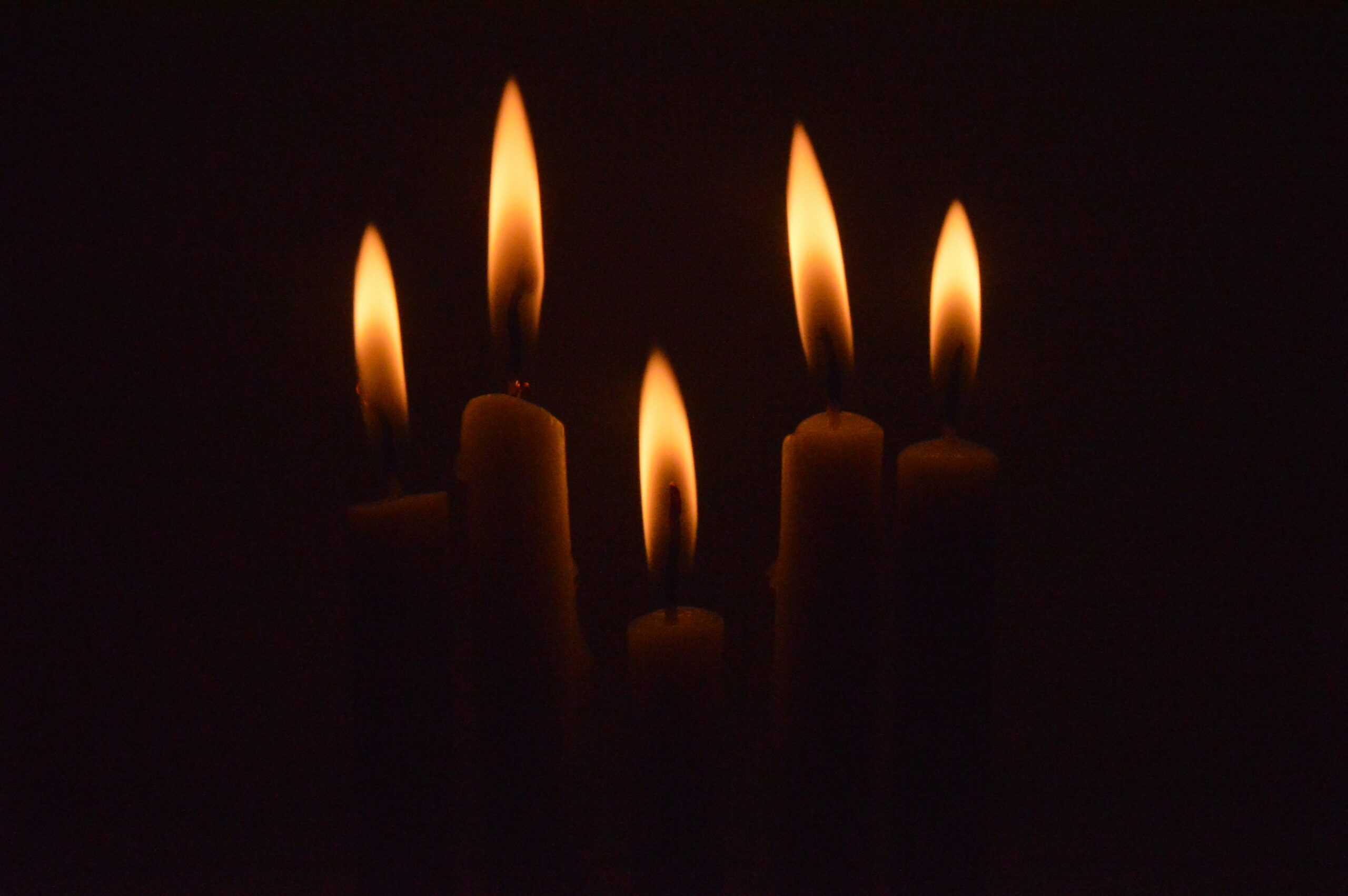 a group of lit candles in the dark